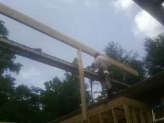 Carpenter setting a ridge beam over a new addition frame — Ice Dam Removal by Roofing Brothers in Dry Fork