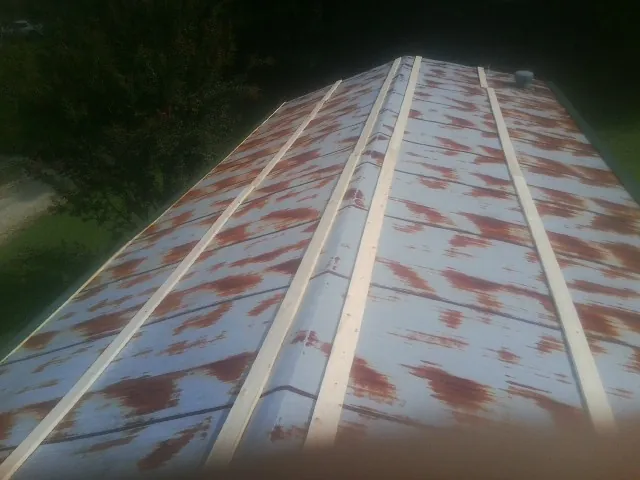 Rusted metal roof panels with new wood purlins before replacement — Storm Damage Roof Repair in Dry Fork by Roofing Brothers