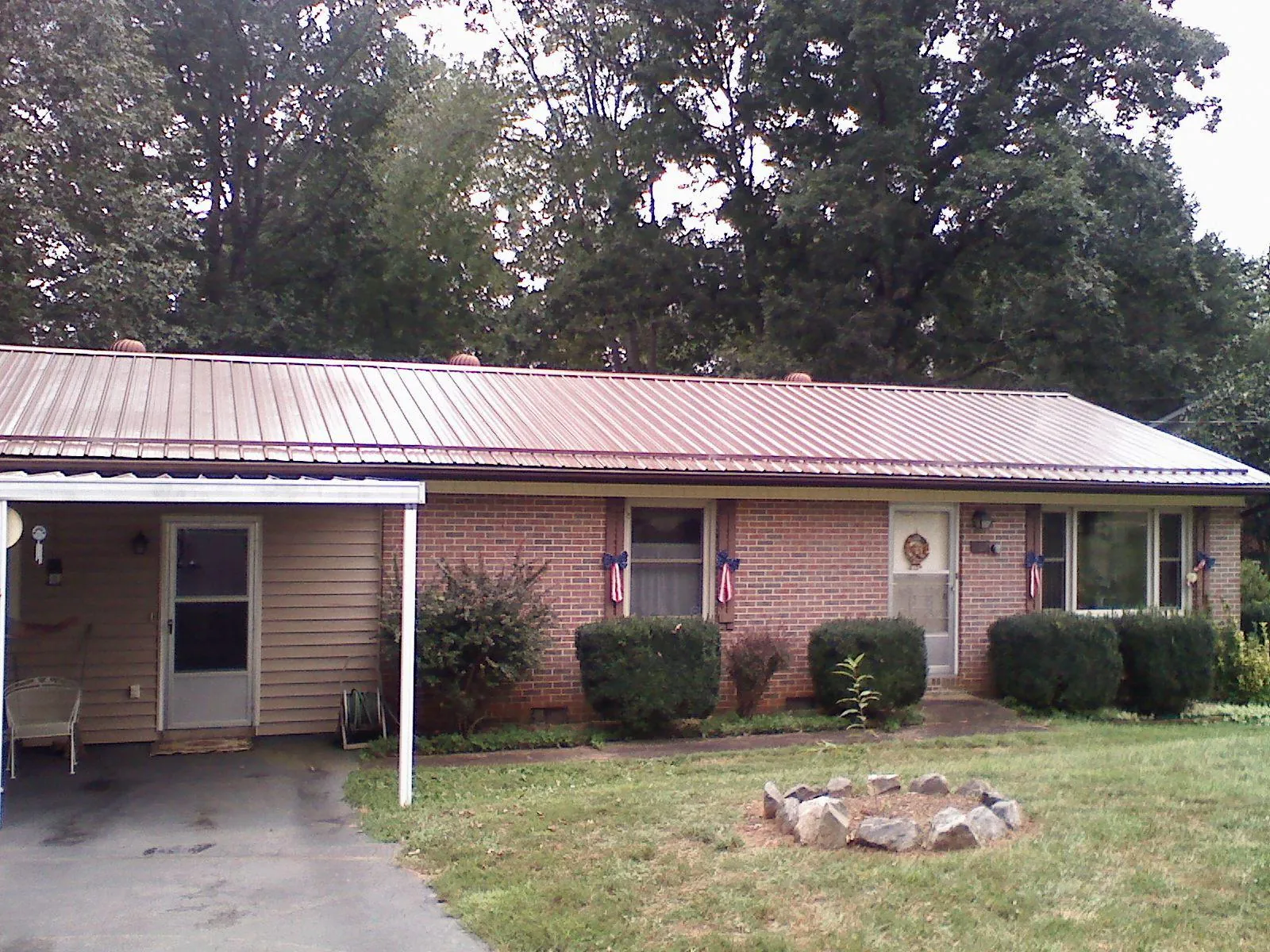 Bronze metal roof and carport on a brick ranch home — Roof Repair work by our crew in Dry Fork
